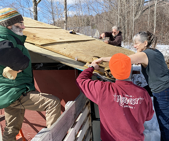 Many hands repair Stowe Farm Community's turkey tractor roof